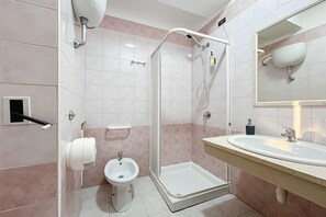 Un bagno moderno con doccia, bidet e lavandino.