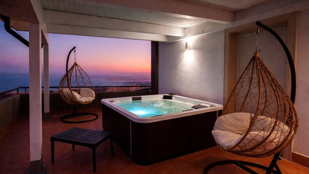 A hot tub, two wicker chairs, a small table, and a view of the sunset. - Bright B&B with Sea View Balcony - 225 - Santangelo - Pool (Monte Sant'Angelo)