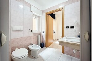 Un baño moderno con inodoro, bidé y lavamanos.