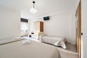 A hotel room with two beds, a TV mounted on the wall, a wardrobe, and a window with curtains. - B&B with Window - 109 - Santangelo - Pool (Monte Sant'Angelo)