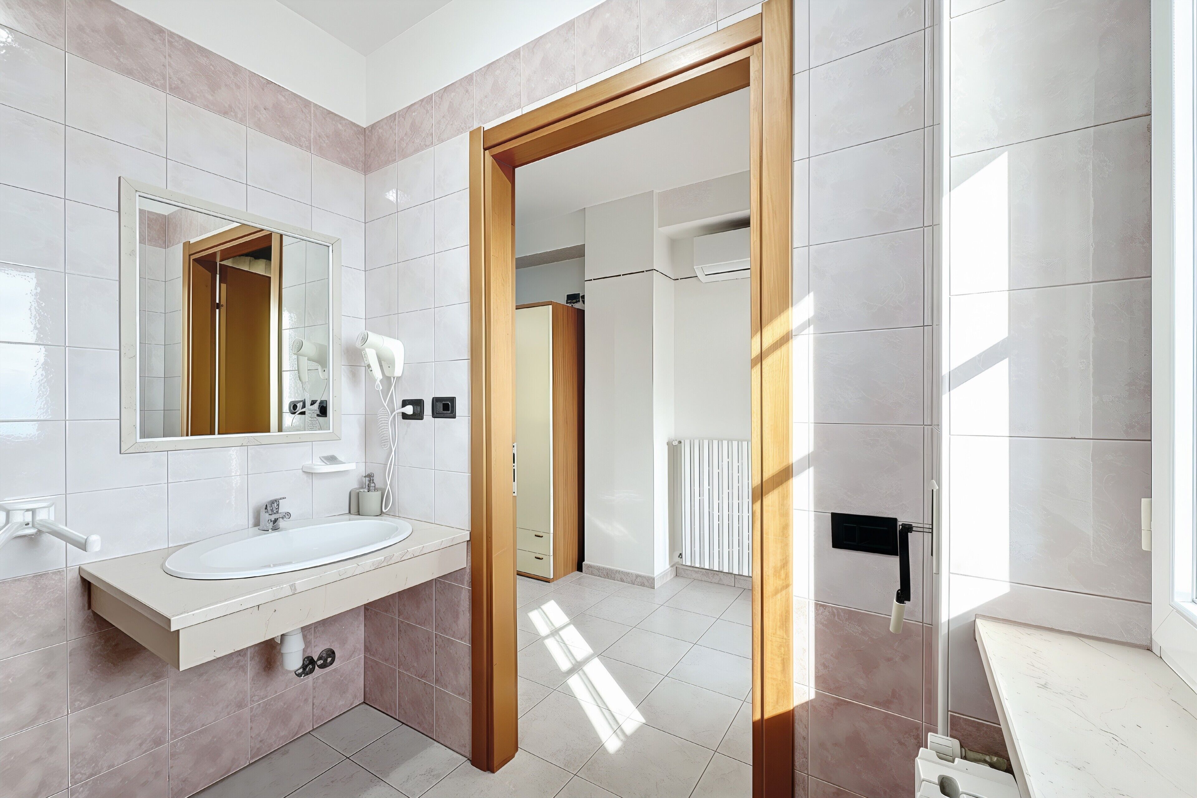 A modern bathroom with a sink, mirror, and shower area.