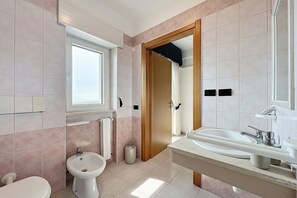 A bathroom with a toilet, bidet, sink, and a window. - Bright B&B with Sea View Balcony – 229 – Santangelo – Pool (Monte Sant'Angelo)