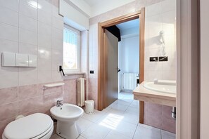 Et badeværelse med toilet, bidet og vask.