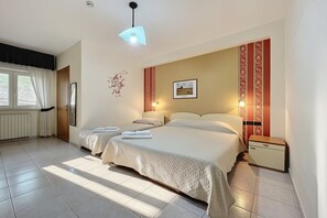 A double bed with a quilted bedspread, a bedside table, a nightstand, a wall-mounted picture, and a window with curtains. - B&B with Window - 236 - Santangelo - Pool (Monte Sant'Angelo)