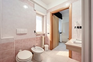 Ein Badezimmer mit Toilette, Bidet und Waschbecken.