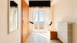 A hallway with a view to a balcony, a door, a radiator, and a window. - B&B Sea View with Balcony - 243- Santangelo - Pool (Monte Sant'Angelo)