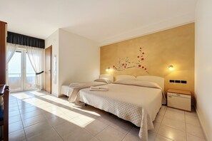 A bedroom with two beds, a window with curtains, a wall-mounted artwork, and bedside lamps. - Bright B&B with Sea View Balcony - 242- Santangelo - Pool (Monte Sant'Angelo)