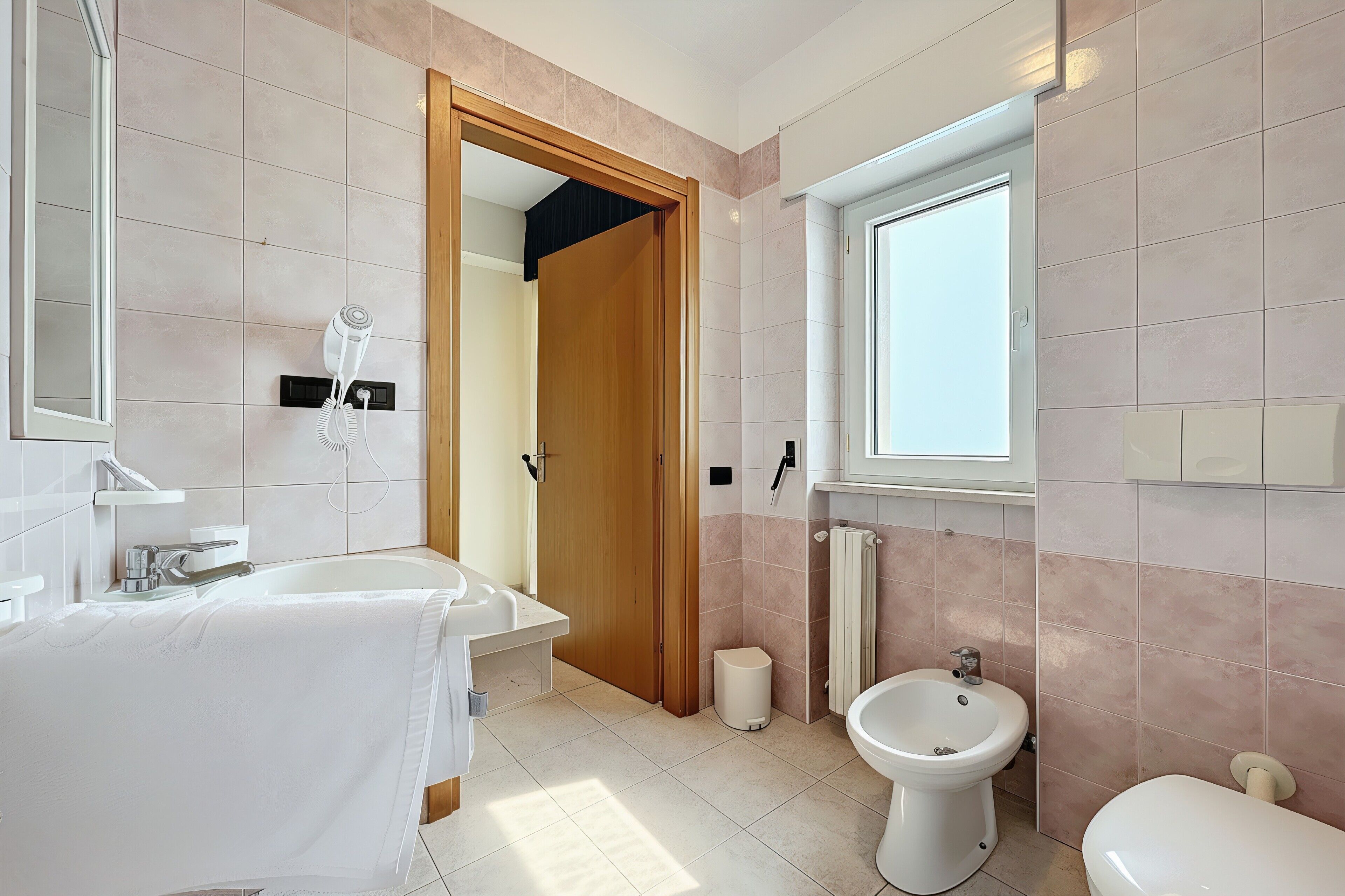 A modern bathroom with a sink, bidet, and toilet.