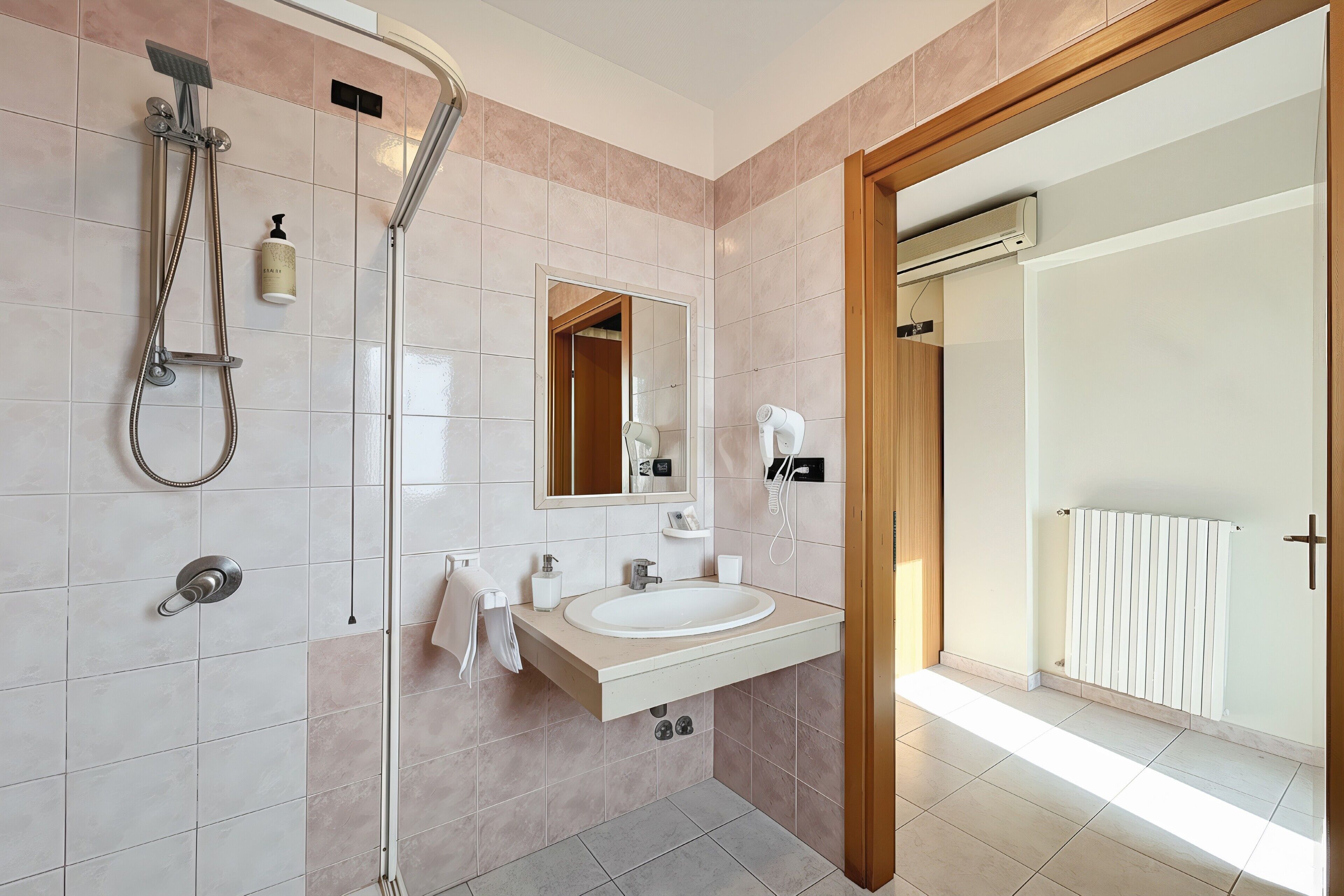 Un baño moderno con ducha, lavabo y espejo.