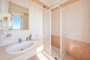 Ein Badezimmer mit Waschbecken, Spiegel und Dusche.