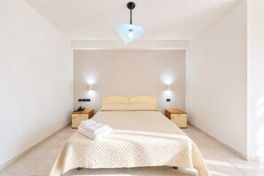 A neatly arranged hotel room with a bed, bedside tables, and a hanging light fixture. - Bright Sea View B&B with Balcony - 345 - Santangelo - Pool (Monte Sant'Angelo)