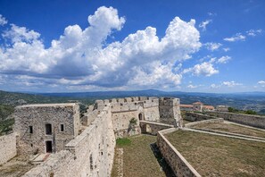An ancient stone fortress with multiple towers and walls, surrounded by a hilly landscape. - Bright B&B with Sea View Balcony - 347 - Santangelo - Pool (Monte Sant'Angelo)