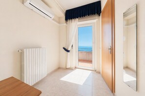 Ein Zimmer mit Meerblick, eine Holztür, ein Heizkörper und eine Sitzbank.