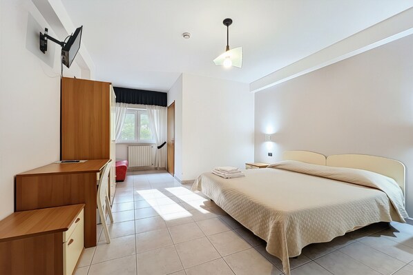 A bedroom with a bed, desk, chair, and a window with curtains. - B&B with Window - 350 - Santangelo - Pool (Monte Sant'Angelo)