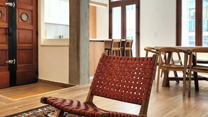 A modern interior with a wooden chair, a patterned rug, and a dining area with wooden furniture. - Spacious 4BR· Families & Groups · Central Apartment · Recoleta (Buenos Aires)