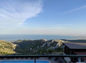 A pool area with lounge chairs, a view of the sea, and rocky terrain. - Apartment with Sea View Window - Santangelo Hotel - Pool (Monte Sant'Angelo)