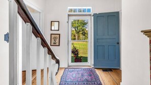 Una escalera que lleva a una puerta con vista a un jardín.