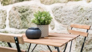 Una mesa de madera con una planta en maceta y un objeto negro.