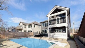 Une maison moderne à deux étages avec une piscine dans le jardin.