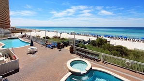 A rooftop pool area with a view of the beach, lounge chairs, and a hot tub. - Seychelles 407 (Panama City Beach)