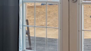 A view through a window with a view of a beach and water.