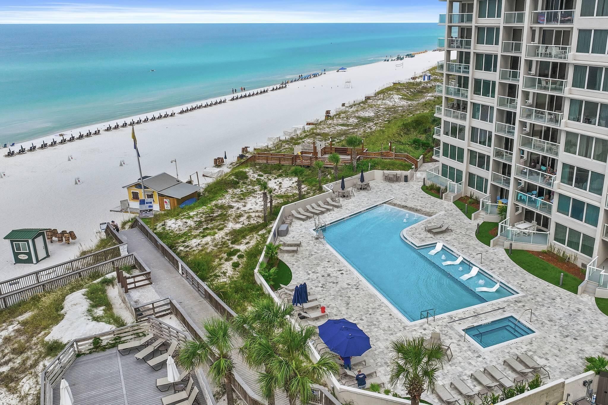 A resort with a pool, beach access, and a view of the ocean.