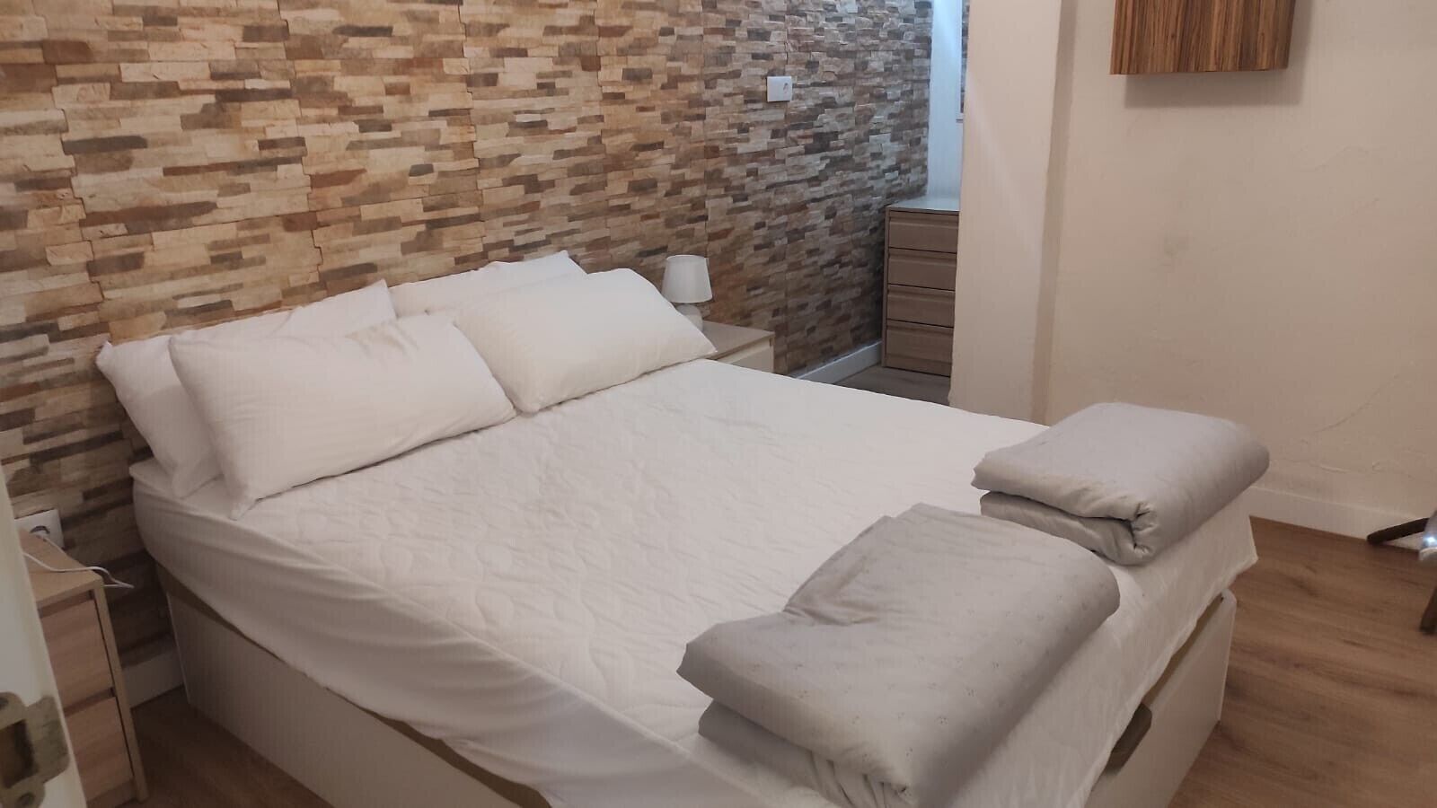 Tabla de planchar con plancha y ropa de cama
