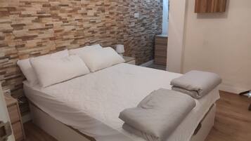 Tabla de planchar con plancha y ropa de cama