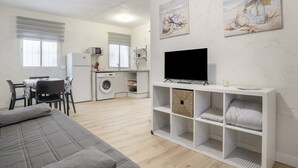 A modern living room with a grey sofa, a flat-screen TV, and a white entertainment unit. - Apartment ‘Vacacional En Vejer’ (Vejer de la Frontera)