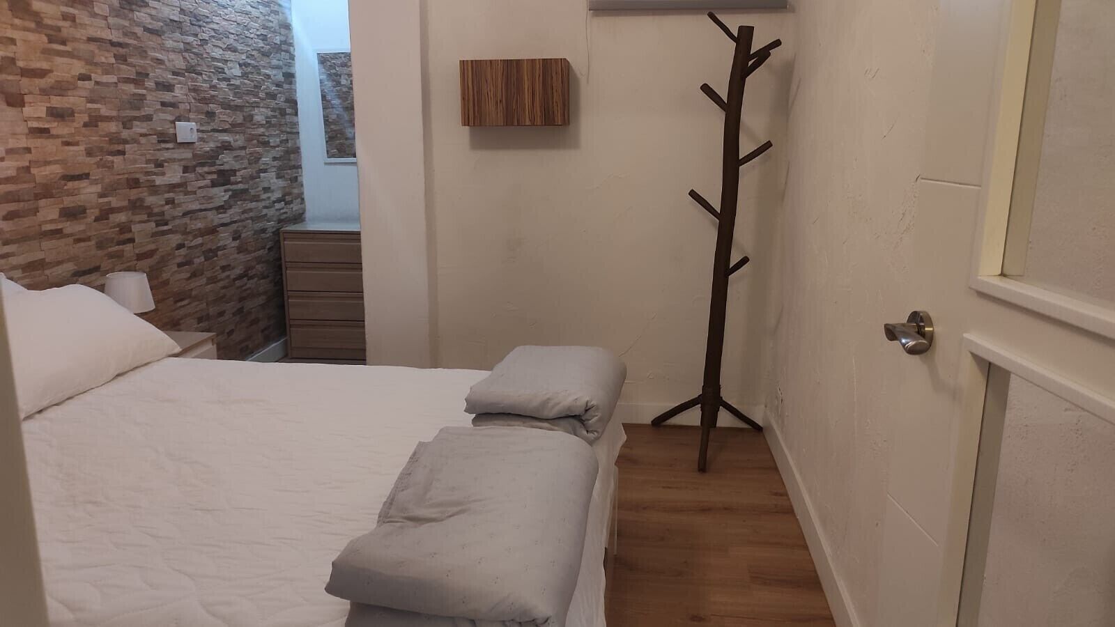 Tabla de planchar con plancha y ropa de cama