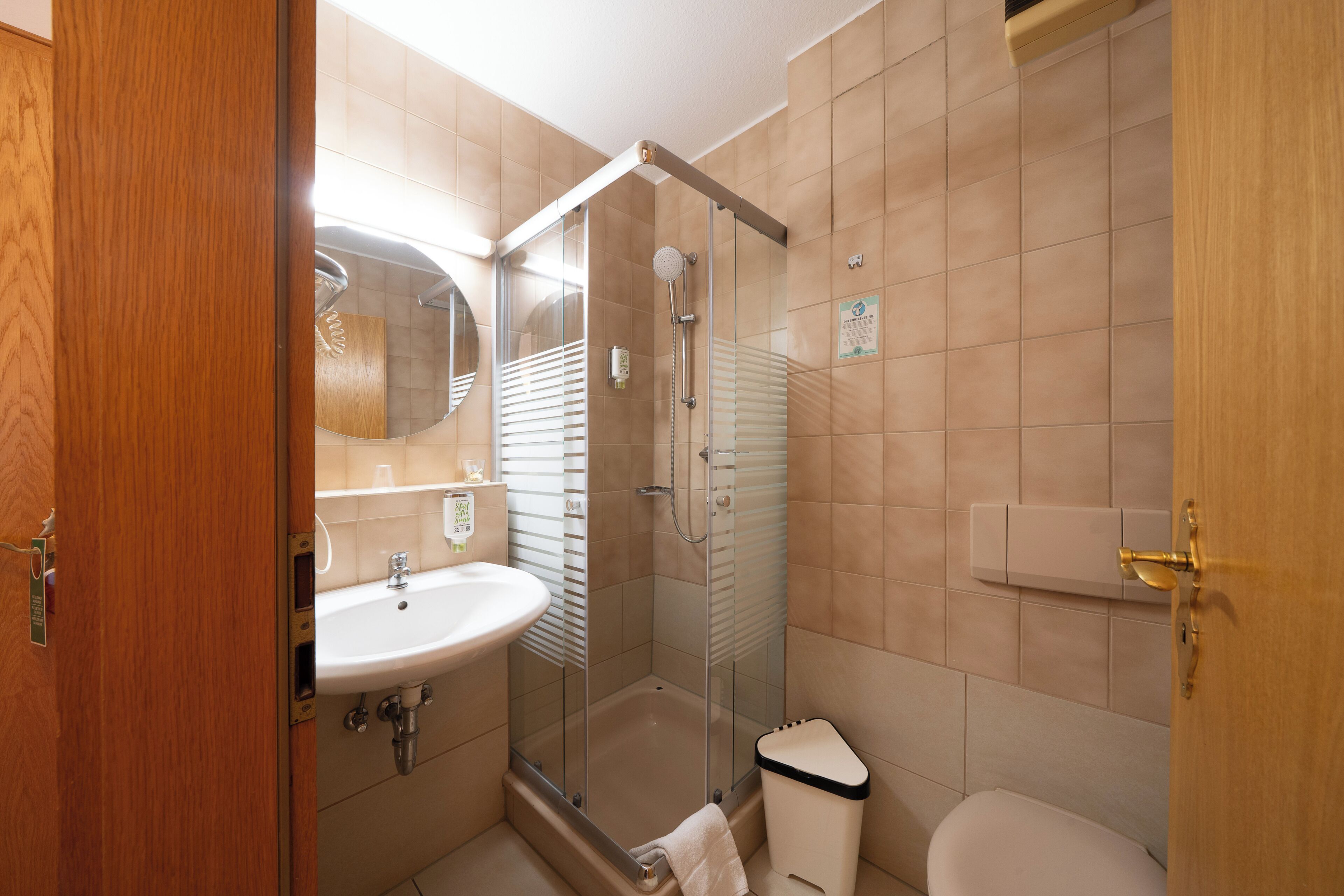 Ein Badezimmer mit einer Duschkabine, einem Waschbecken und einer Toilette.