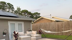 A backyard patio with outdoor furniture, a hammock, and a wooden deck. - Private Pool Oasis Less Than 2 Miles to PC Beach! (Panama City Beach)