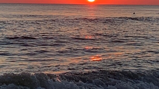 A sunset over a calm sea with waves approaching the shore. - Private Pool Oasis Less Than 2 Miles to PC Beach! (Panama City Beach)