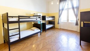 A room with bunk beds, a desk, and a window with curtains. - Spicy Hostel (Budapest)