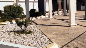 A multi-story residential building with balconies, a covered outdoor area, and a gravel courtyard. - Studio Renovated 4 sleeps Clim balcony Parking port beach swimming pool Cap d'Agde (Agde)