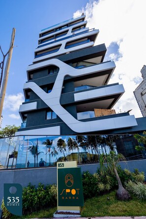 Ein modernes Gebäude mit einzigartigem architektonischen Design, mit mehreren Balkonen und einer Glasfassade.