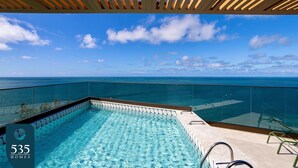 Une piscine d’un bleu éclatant, séparée du reste par une paroi de verre, et offrant une vue imprenable sur l’océan.