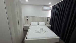 A modern hotel room with a large bed, bedside tables, an air conditioning unit, and a wardrobe. - Zeynus Hotel Kadıköy (İstanbul)