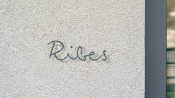 A textured wall with the word 'Ribes' written in cursive.