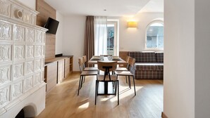 A modern dining area with a wooden table, chairs, and a white decorative panel.