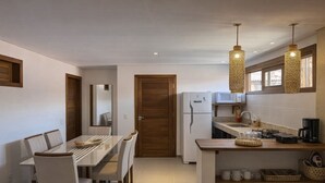 A compact kitchen with a refrigerator, microwave, and a coffee maker on the counter. - Apartamento Messina  (Jijoca de Jericoacoara)