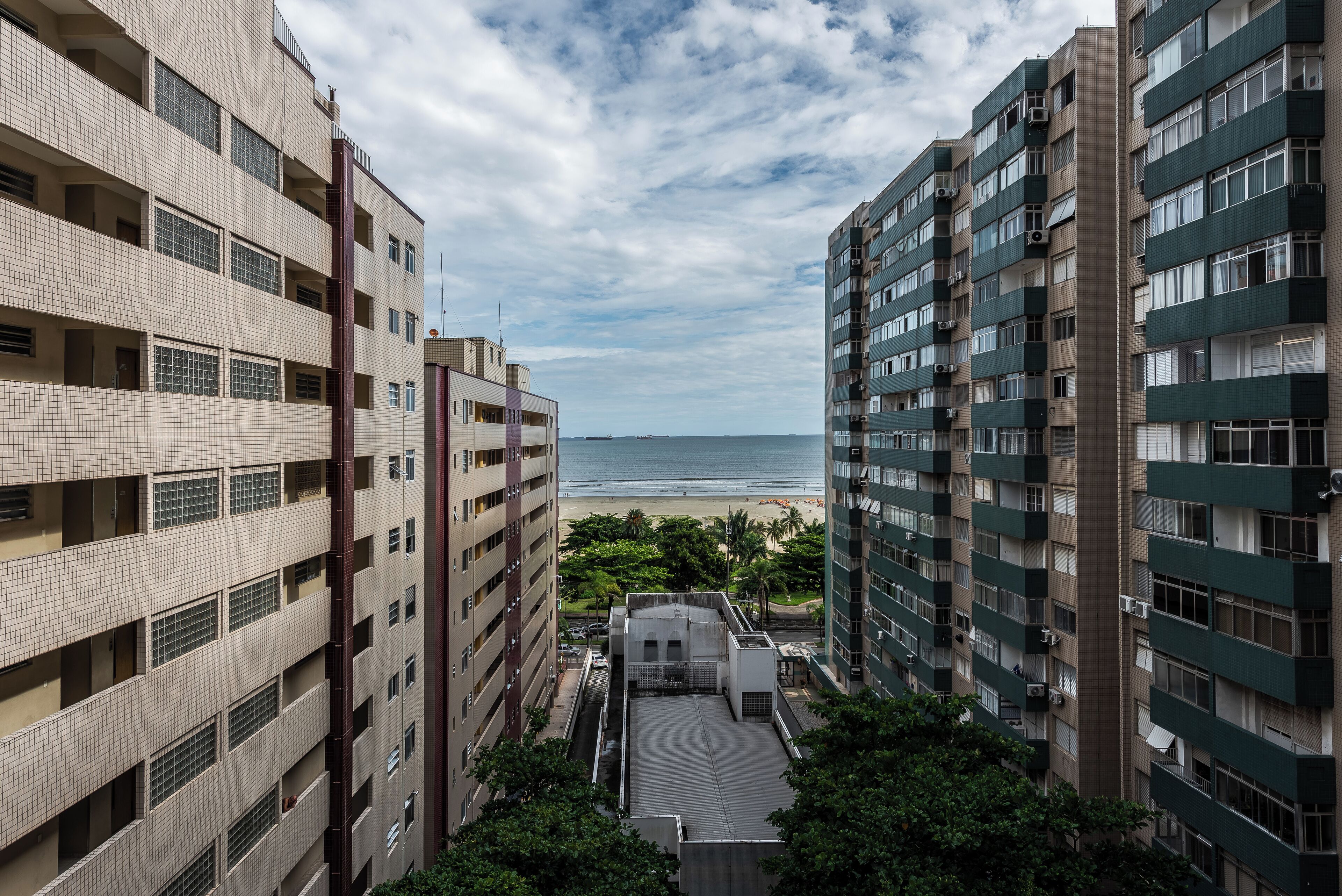 Un immeuble de grande hauteur doté de nombreux balcons donnant sur une plage.