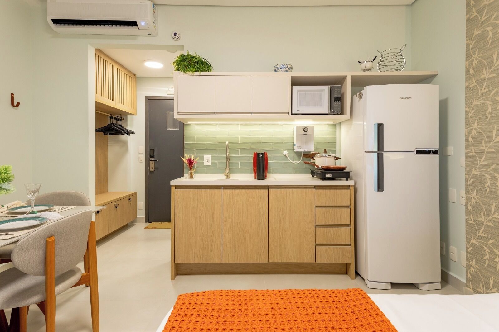 A compact kitchen with a microwave, a refrigerator, and a sink.