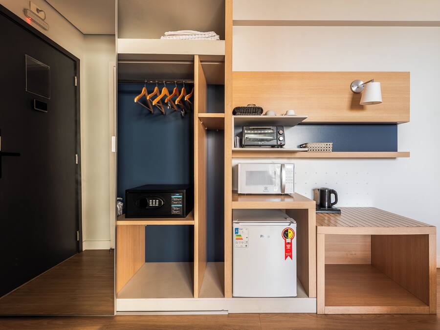 Una kitchenette compacta equipada con microondas, tostadora y refrigerador.