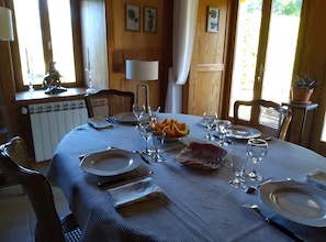 Tavola imbandita con piatti, posate, bicchieri e un vassoio di frutta.