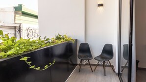 A modern interior with a black planter wall, two black chairs, and a glass partition. - MARUVA Hotel Ejecutivo (Tecomán)