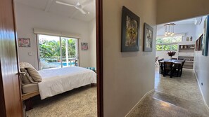 Ein Schlafzimmer mit Bett, einer Glastür zum Balkon und einer Essecke mit Tisch und Stühlen.