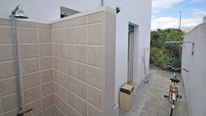 A narrow outdoor space with tiled walls, a bicycle, and a small shed. - Villetta Macao 2 in Torre Suda (Racale)