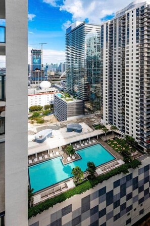 Ein Hochhaus mit Pool und Lounge auf dem Dach.