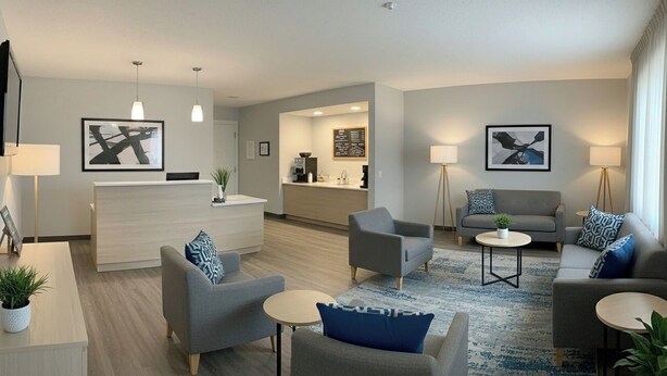 A modern hotel room with a living area, a dining area, and a kitchenette. There are two sofas, a coffee table, and a TV mounted on the wall. - Hotel Atlantiis Suites by Signature Stays (New Delhi)